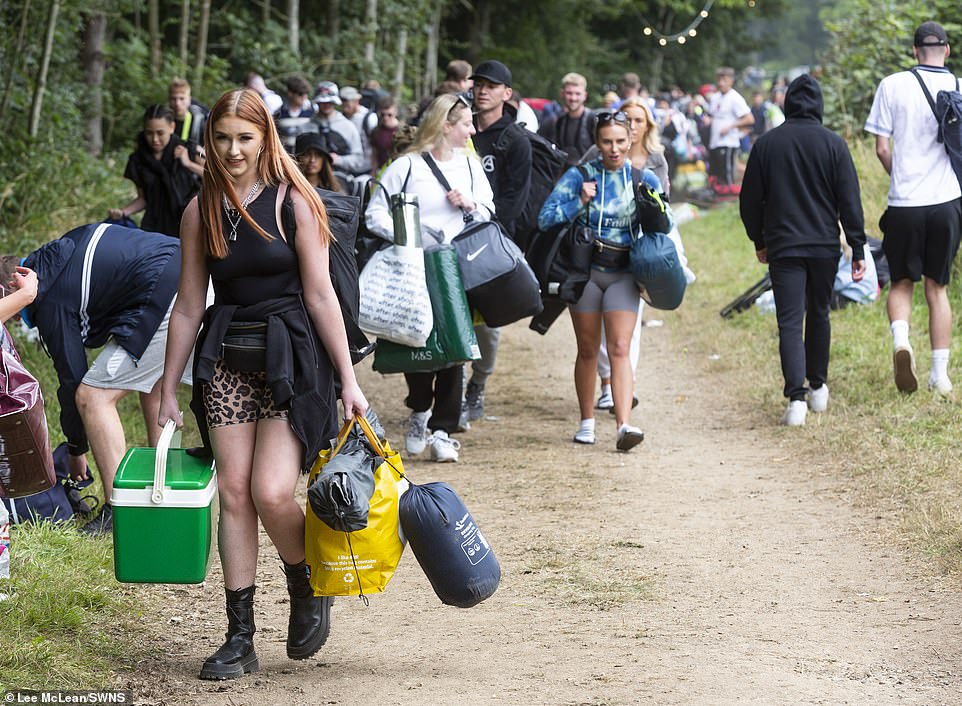Crowds pictured arriving with their belongings and camping equipment at Leeds Festival in Bramham Park, West Yorkshire