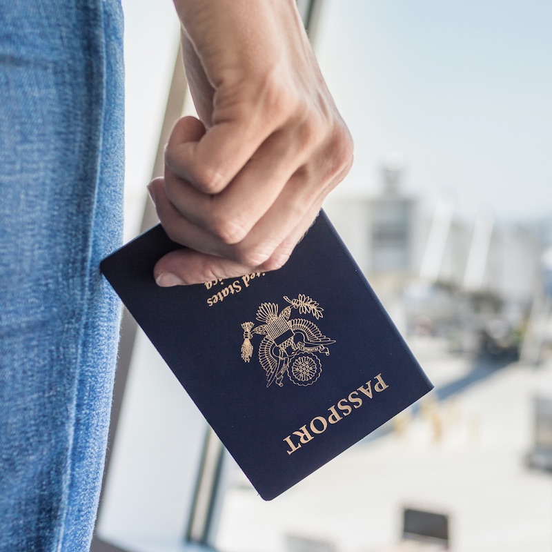 Traveler Holding An U.S. Passport Upside Down At The Airport, International Travel