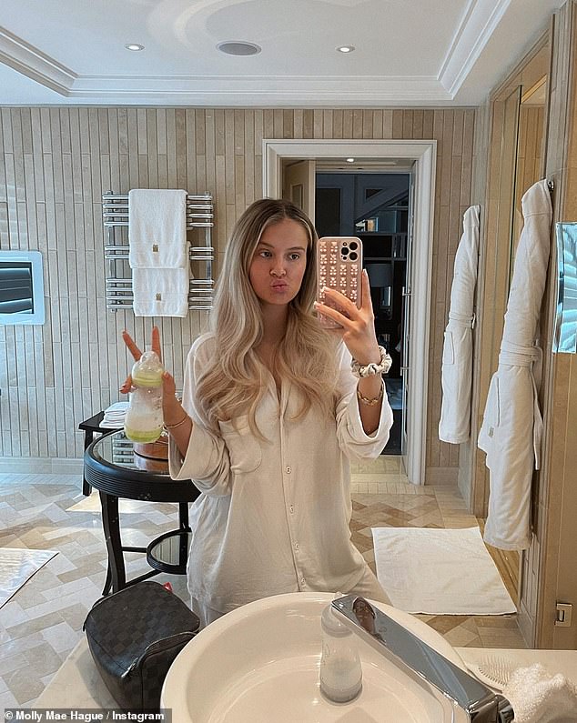 Cosy: The influencer pouted for a bathroom selfie in a pair of crisp white pyjamas while holding up a bottle for Bambi