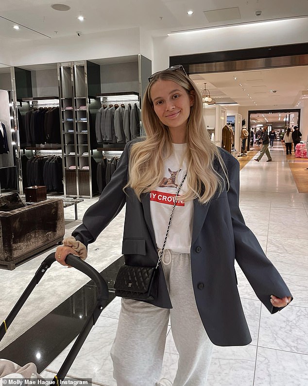 Chic: Molly-Mae pushed her baby girl in her pram as she kept casual in a pair of grey tracksuit bottoms which she tucked a white T-shirt into and wore a grey blazer as she hit the shops